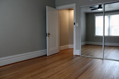 A room with a wooden floor and a white door.