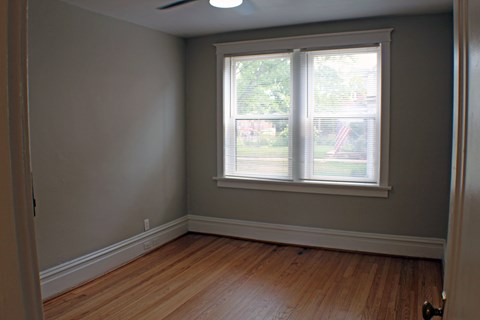 A room with a window and wooden floors.