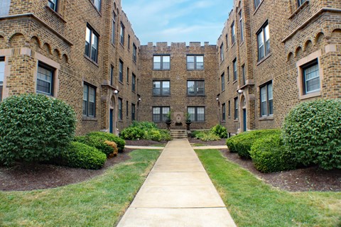 A long concrete walkway leads between two rows of buildings.