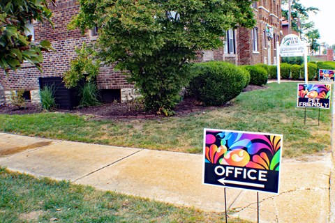 A sign that says "OFFICE" is in front of a building.