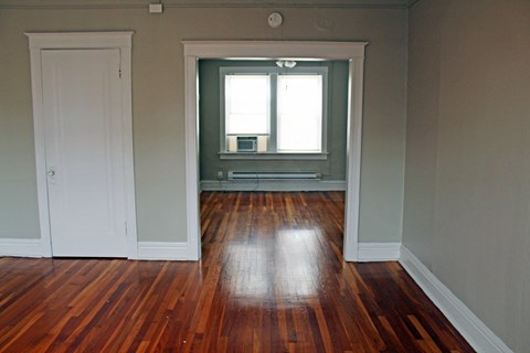 A room with a wooden floor and a window.