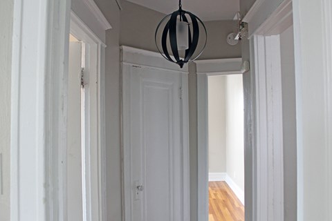 A white hallway with a hanging light fixture.