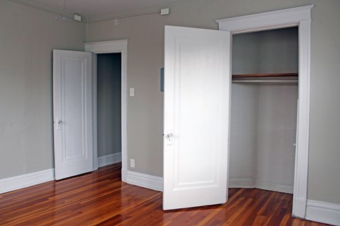 A room with a white door and a wooden floor.