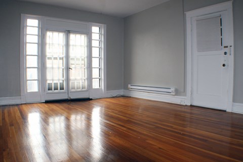 A room with a white door and a window with blinds.