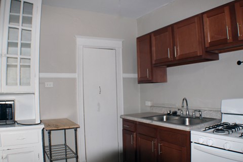 A kitchen with white appliances and brown cabinets.
