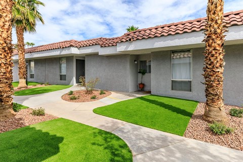 a house with a yard and palm trees