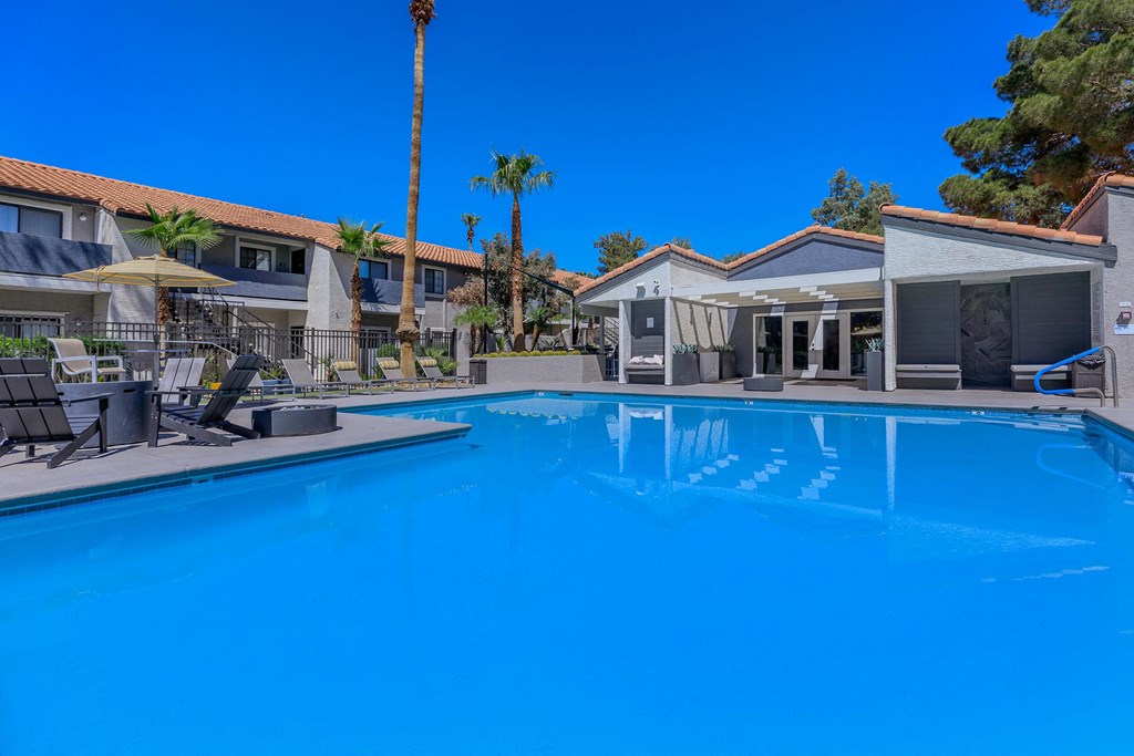 the swimming pool at the resort combines a large blue pool with chairs and tables