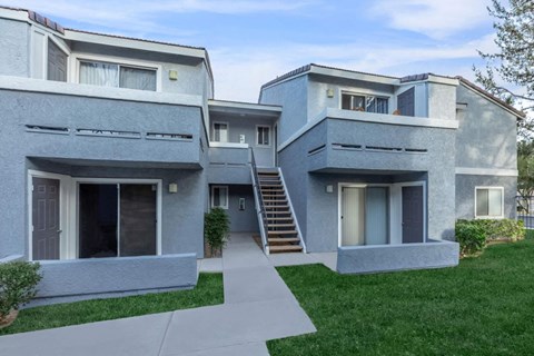 A modern two-story house with a grey exterior and a white front door.