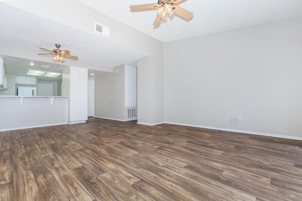 the living room and dining room with wood flooring and a ceiling fan