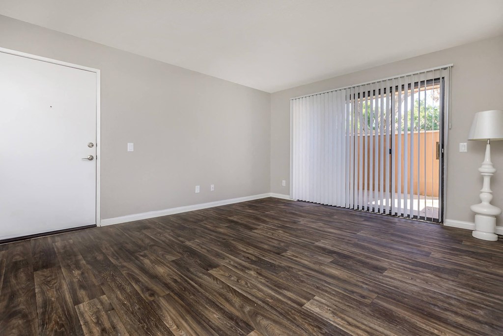 a living room with a sliding glass door and wood flooring