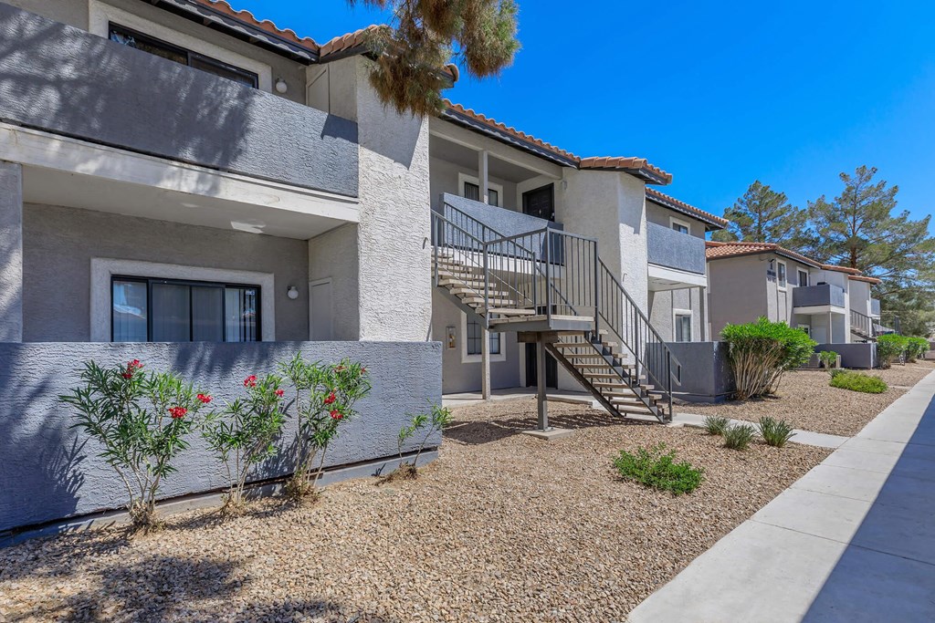 a building with stairs and plants in front of it