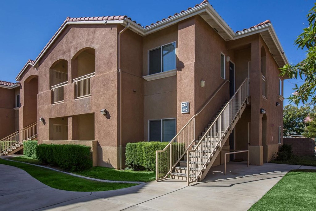 A two-story apartment building with a staircase leading to the second floor.
