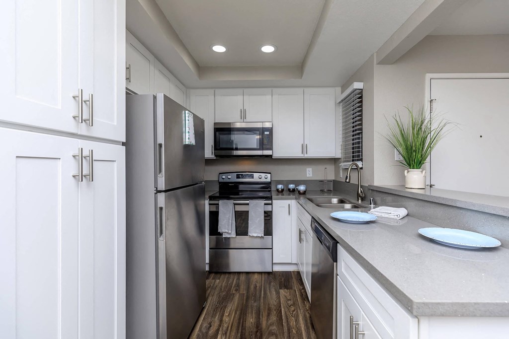 a kitchen with stainless steel appliances and white cabinets