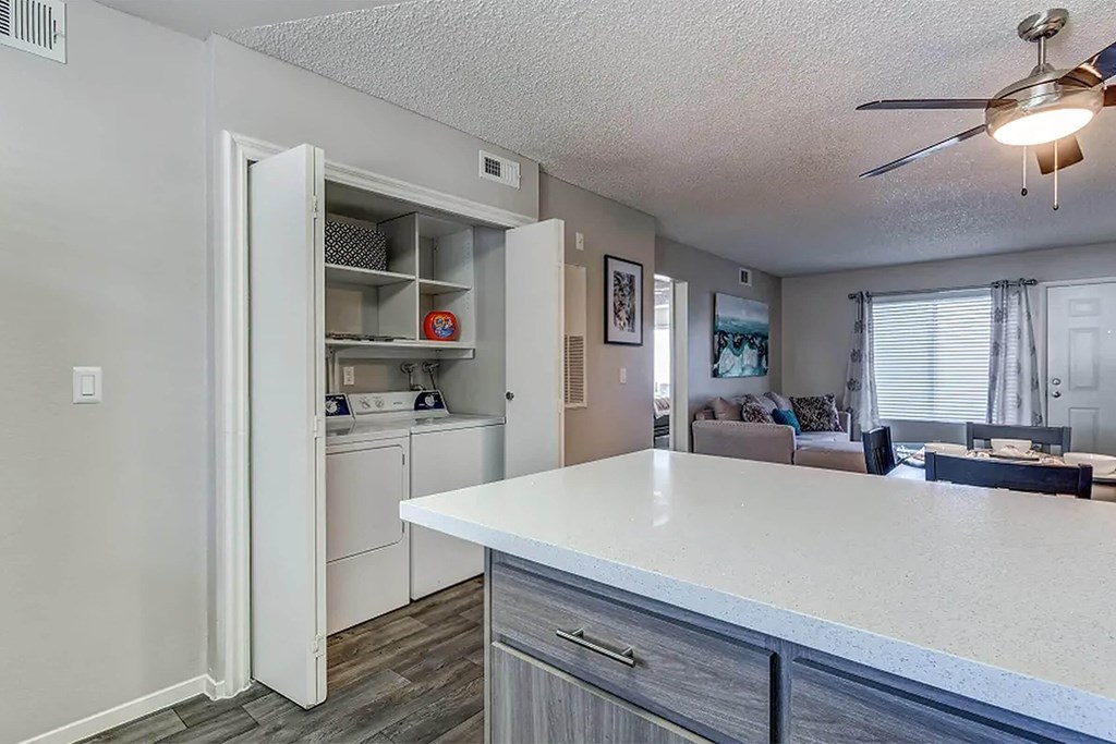 a kitchen with a counter top next to a living room