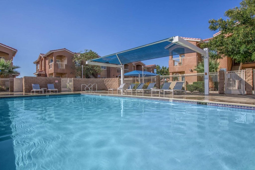 A swimming pool with a blue cover and chairs around it.