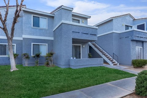A modern house with a grey exterior and a tree in front.