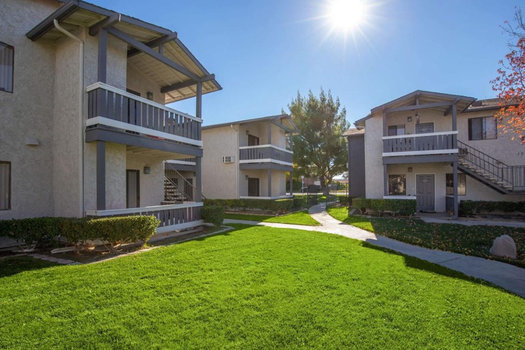 a grassy yard in front of some apartments