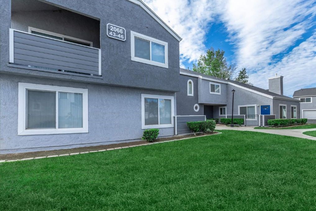 a gray building with a lawn in front of it