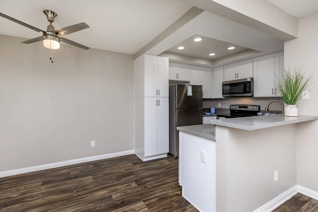 a kitchen with a counter and a ceiling fan