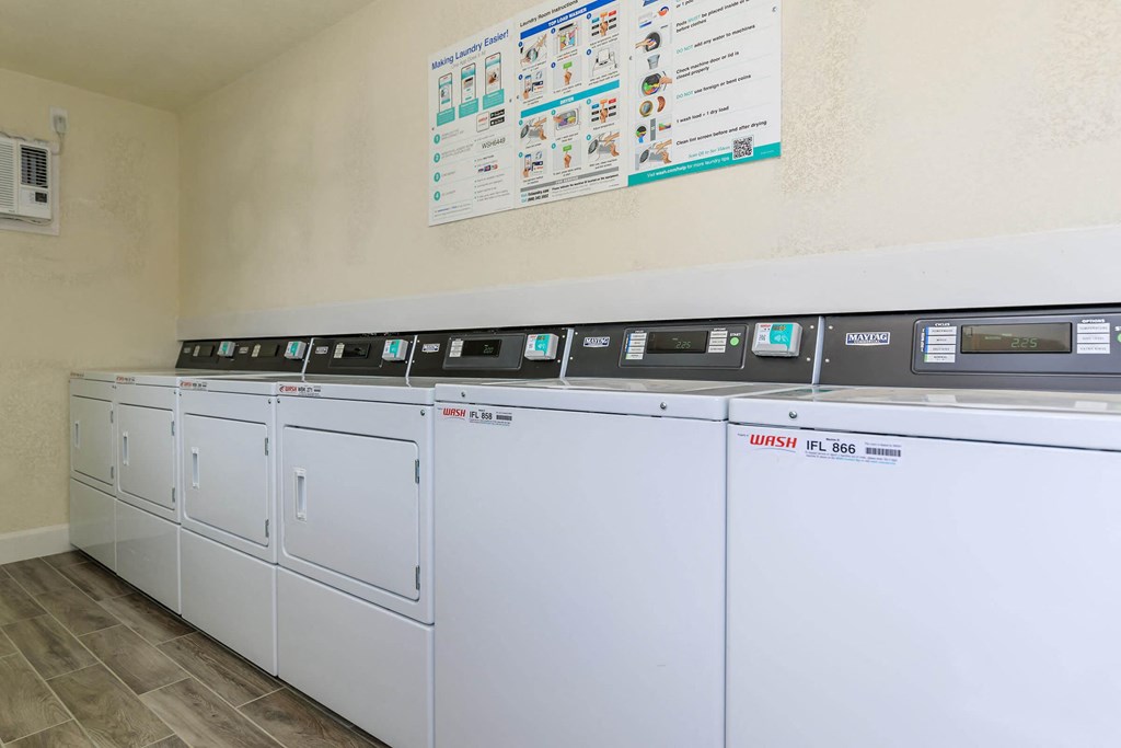 a row of washers and dryers in a laundry room