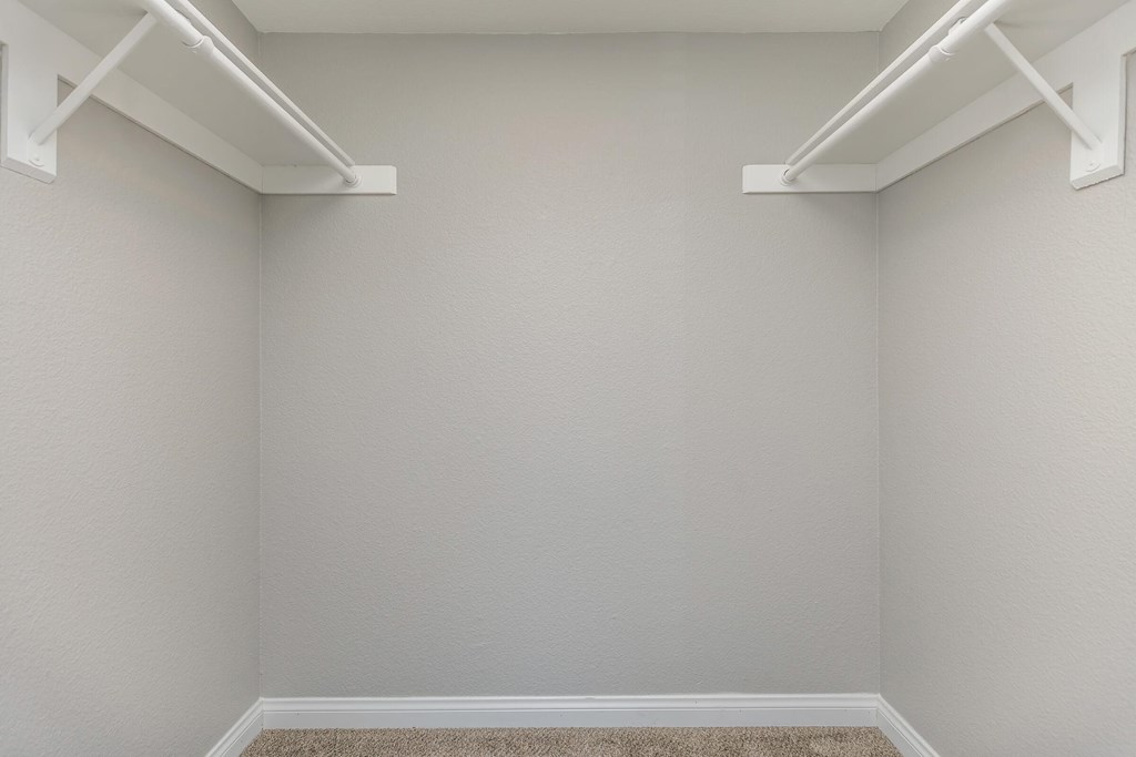 an empty room with two white shelves on the wall