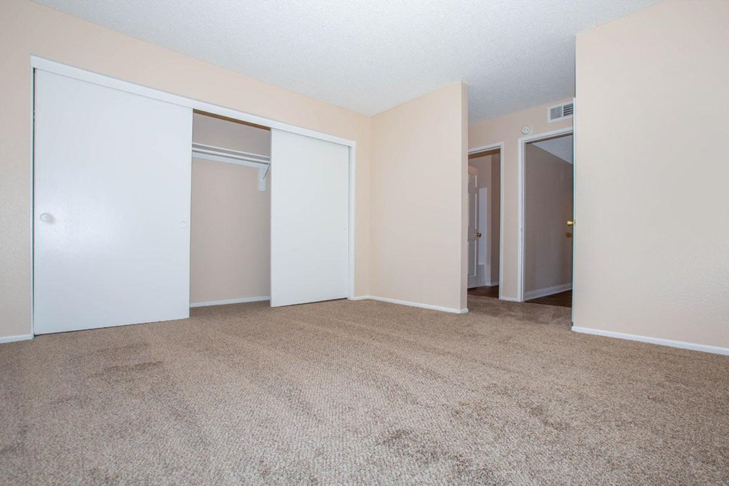 an empty living room with sliding closet doors