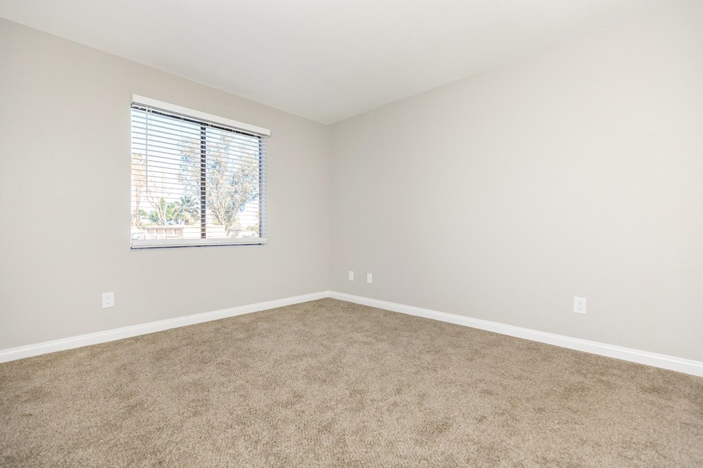 an empty room with carpet and a window