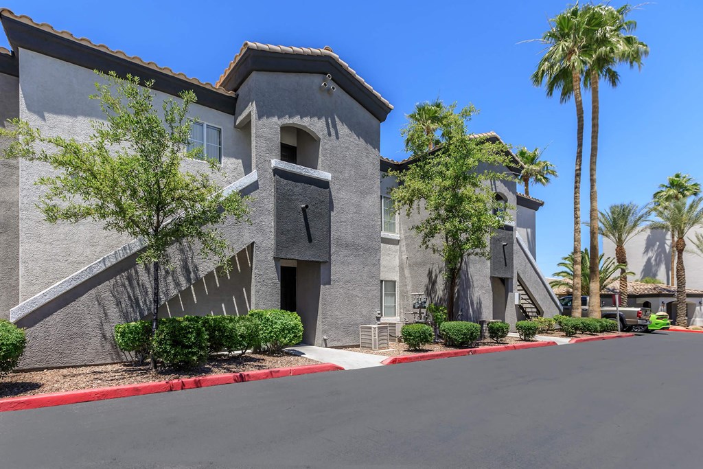 a large gray building with palm trees in front of it