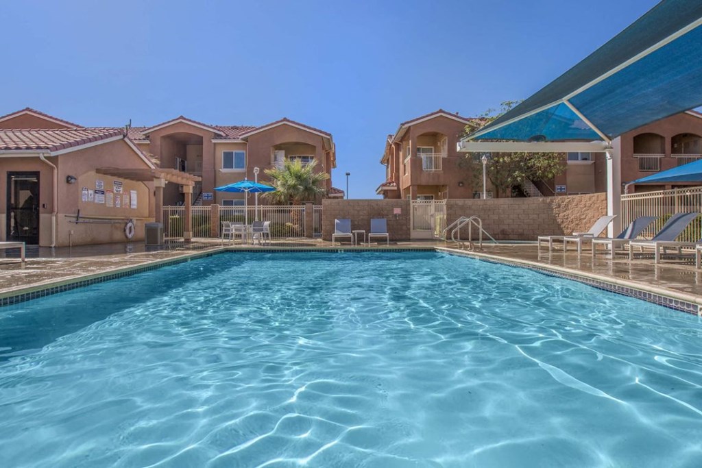 A swimming pool in front of a row of houses.