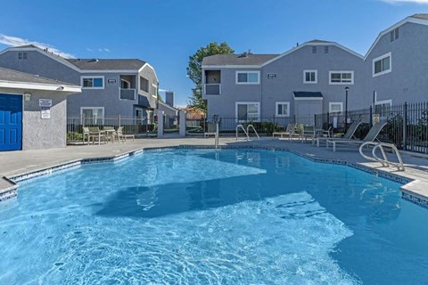 a large swimming pool with apartments in the background