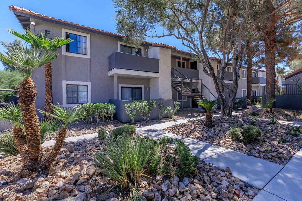 a courtyard with trees and plants in front of a building