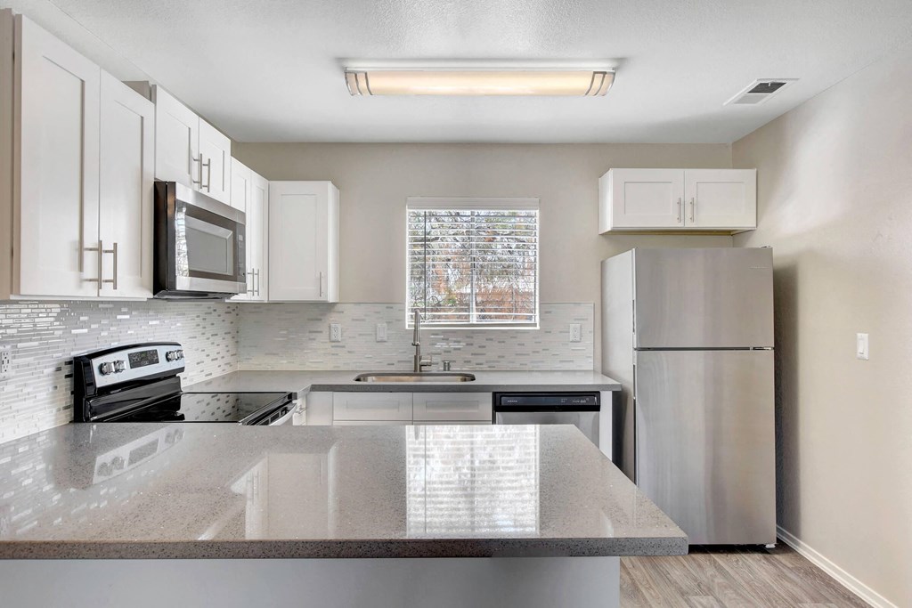 a kitchen with stainless steel appliances and white cabinets