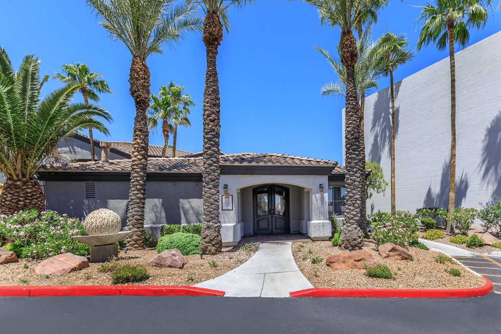 the front of a house with palm trees and a driveway