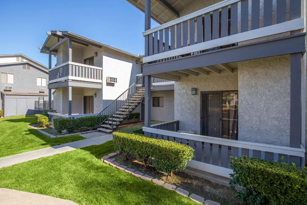 a building with a staircase and a yard in front of it