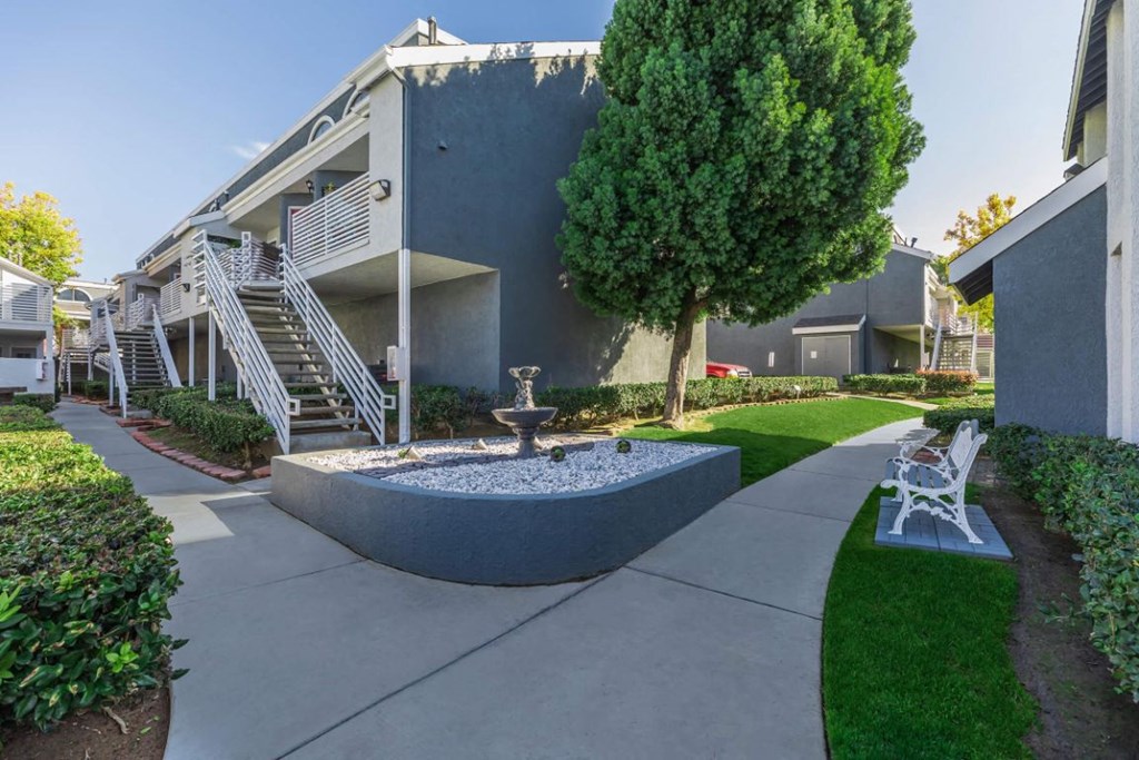 a courtyard with a fountain in front of an apartment building