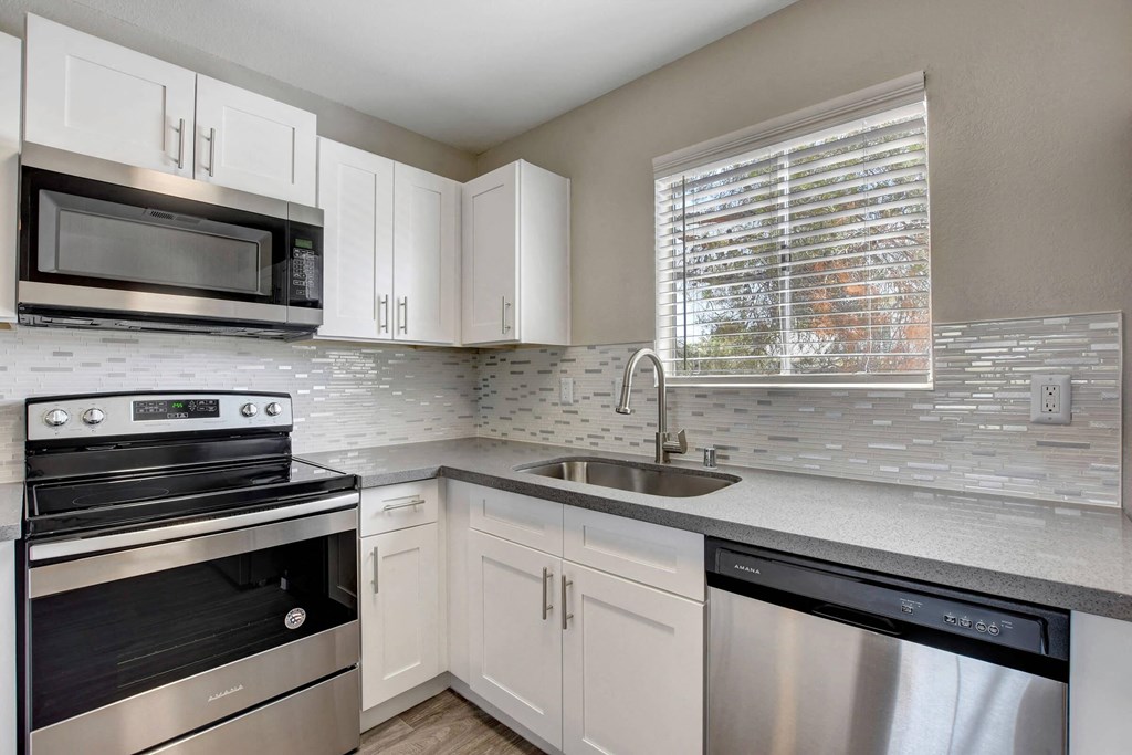 a kitchen with stainless steel appliances and white cabinets