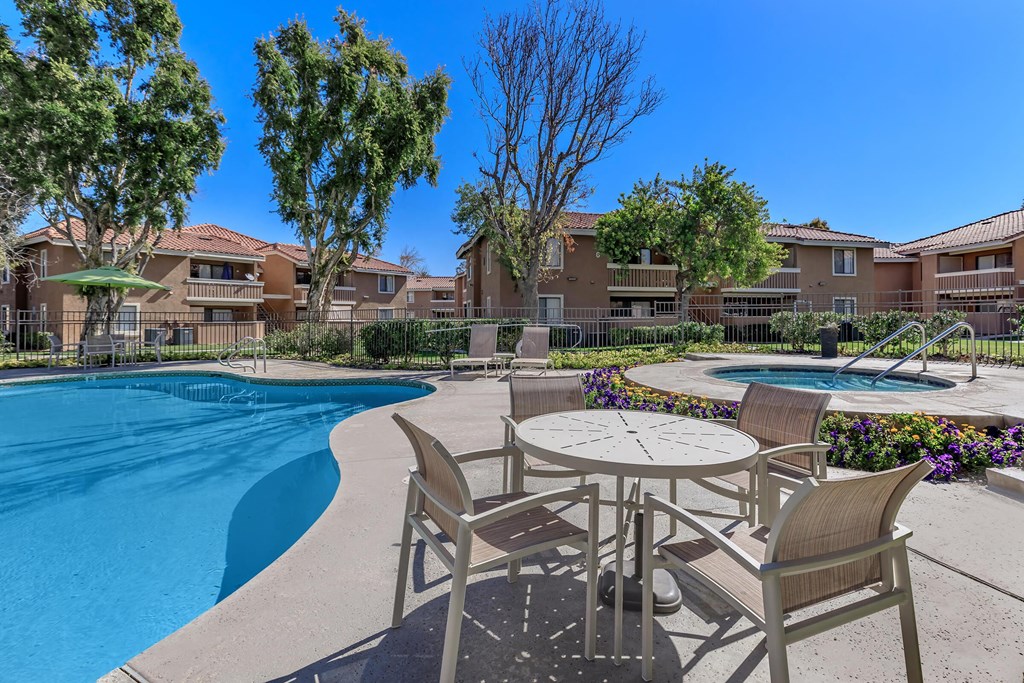 a patio with a table and chairs next to a swimming pool