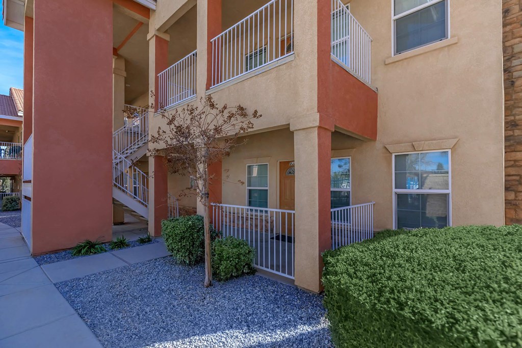 an exterior view of an apartment building with balconies and a sidewalk