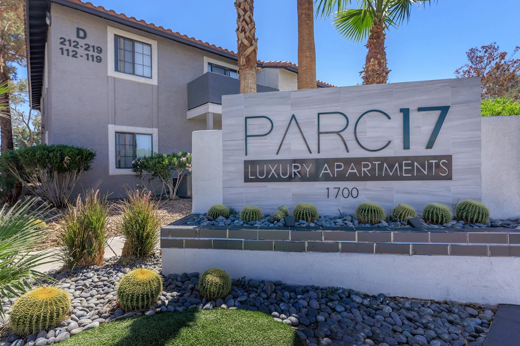 a building with a sign and some cactus in front of it