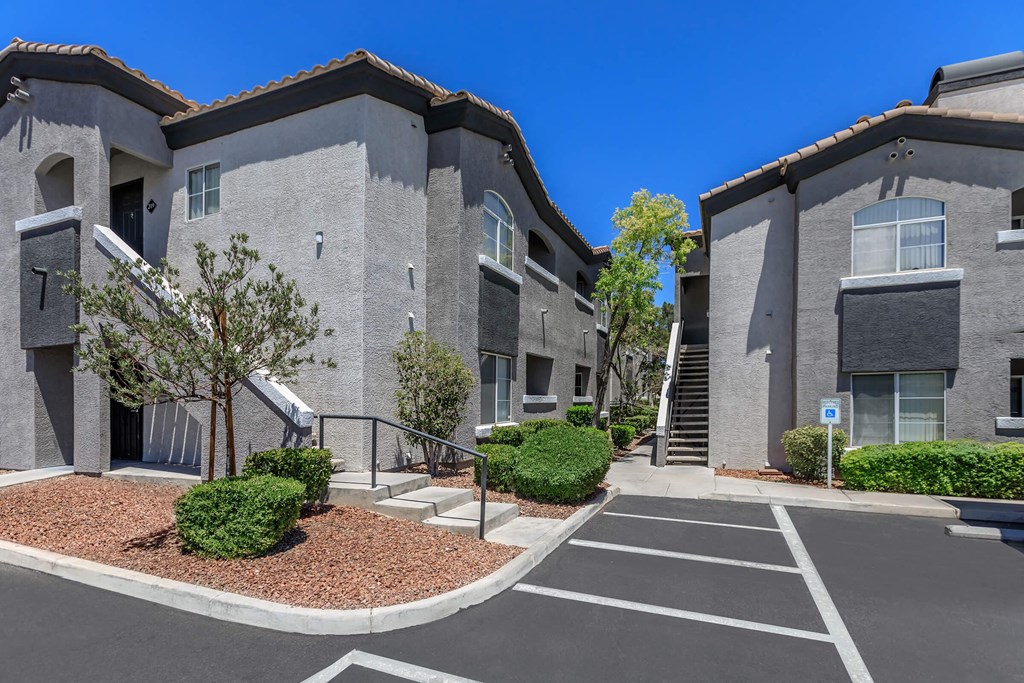 a building with stairs and a parking lot in front of it