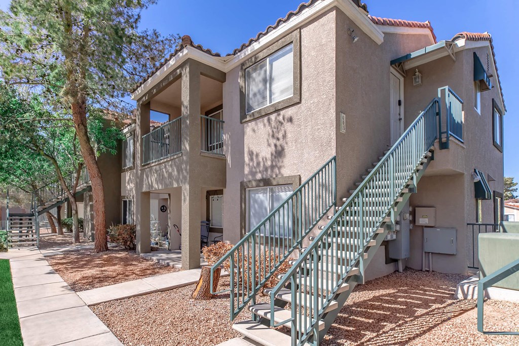 a building with stairs and a tree in front of it