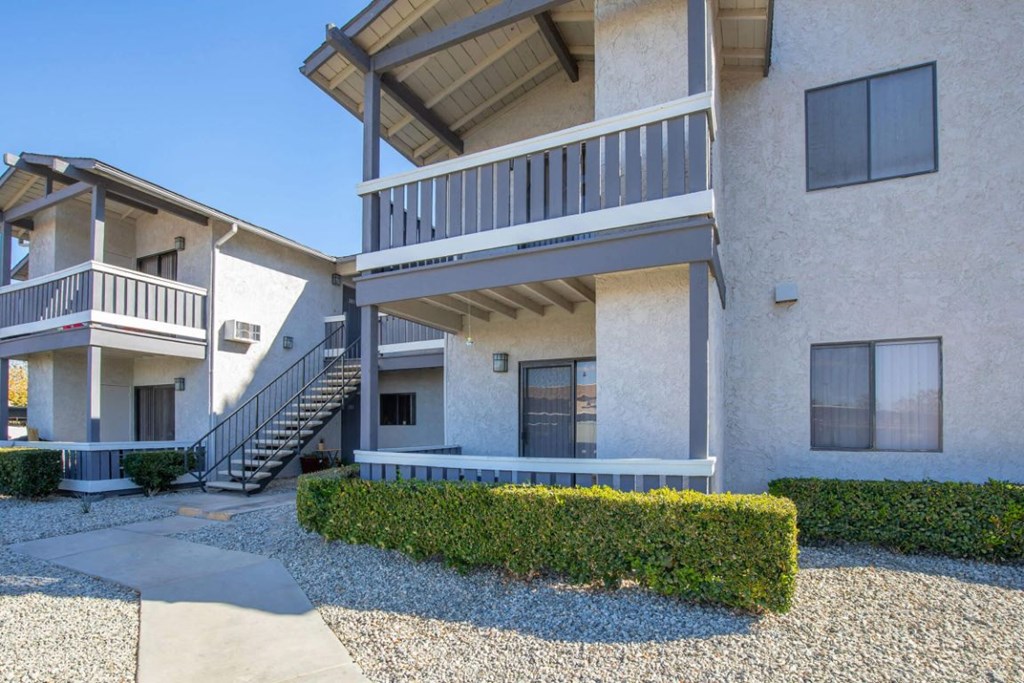an exterior view of an apartment building with stairs and a sidewalk