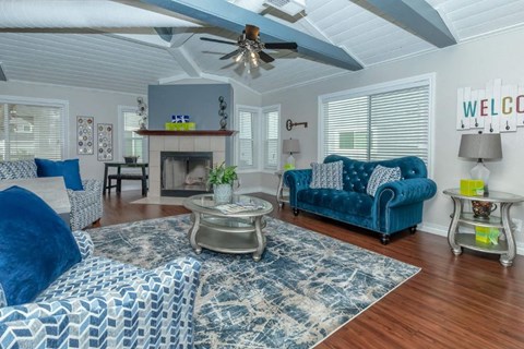 a living room with blue furniture and a ceiling fan