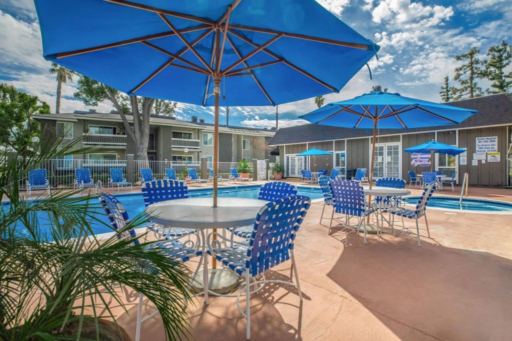 our apartments have a pool and patio with chairs and umbrellas