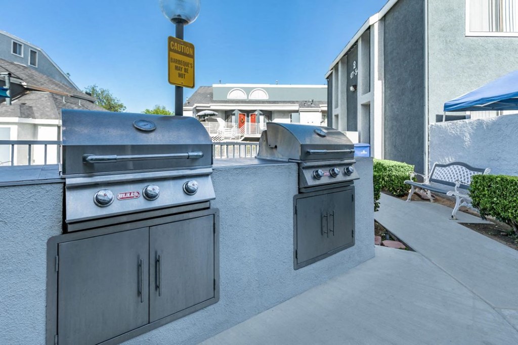 two stainless steel bbq grills on the side of a building