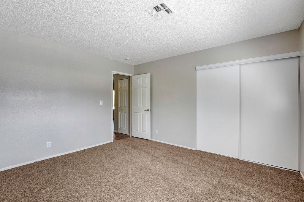 an empty living room with white walls and carpet