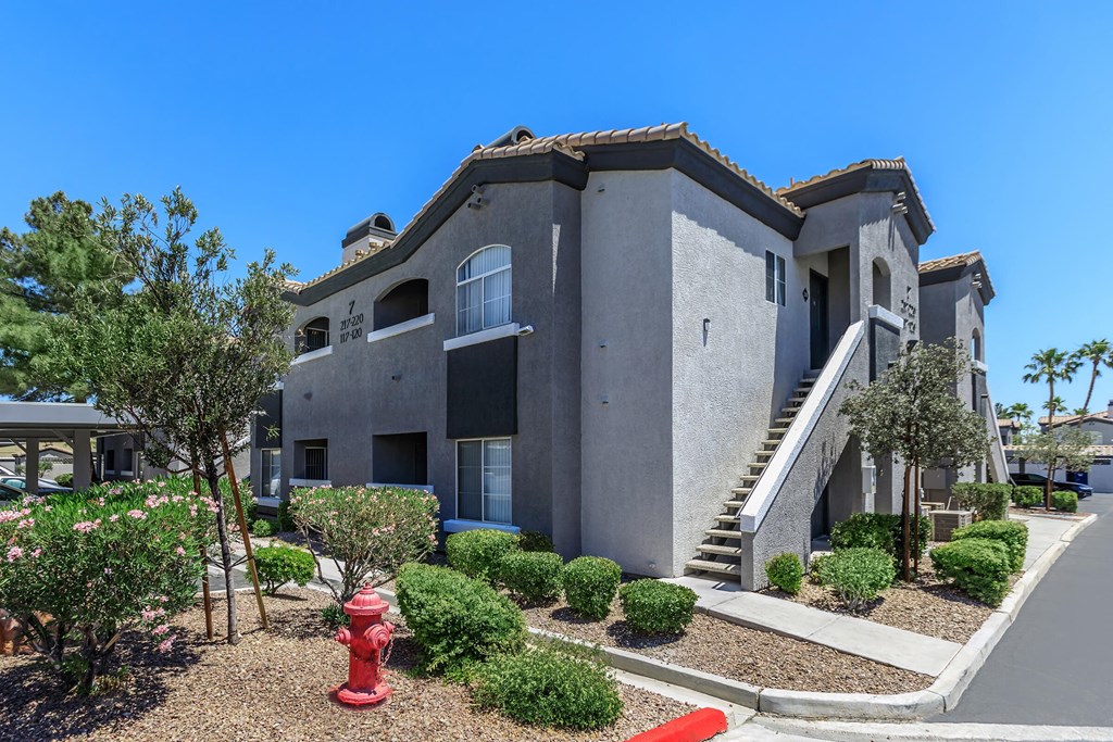an apartment building with a red fire hydrant in front of it