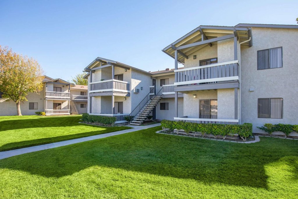an exterior view of apartments with lawns and balconies