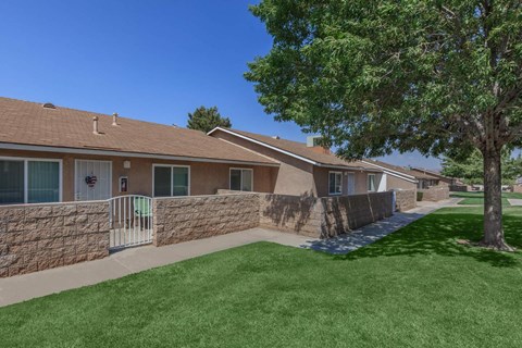 A row of houses with a green lawn in front.