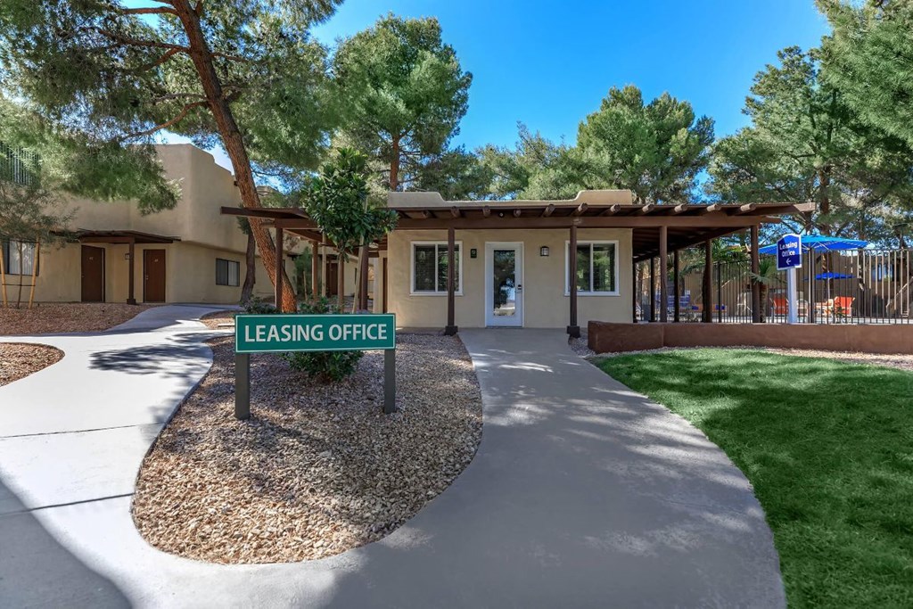 A leasing office is surrounded by a landscaped area with a gravel bed and a concrete walkway.